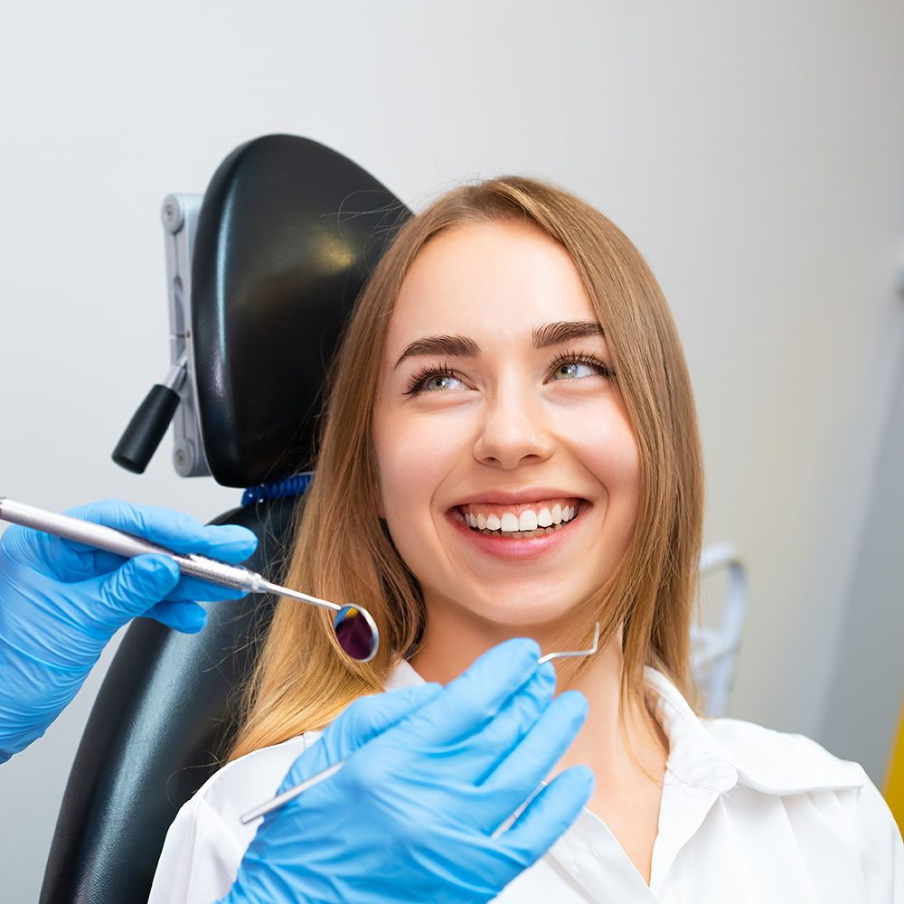 Woman smiling with bright healthy teeth during a routine checkup at a Lethbridge dental clinic